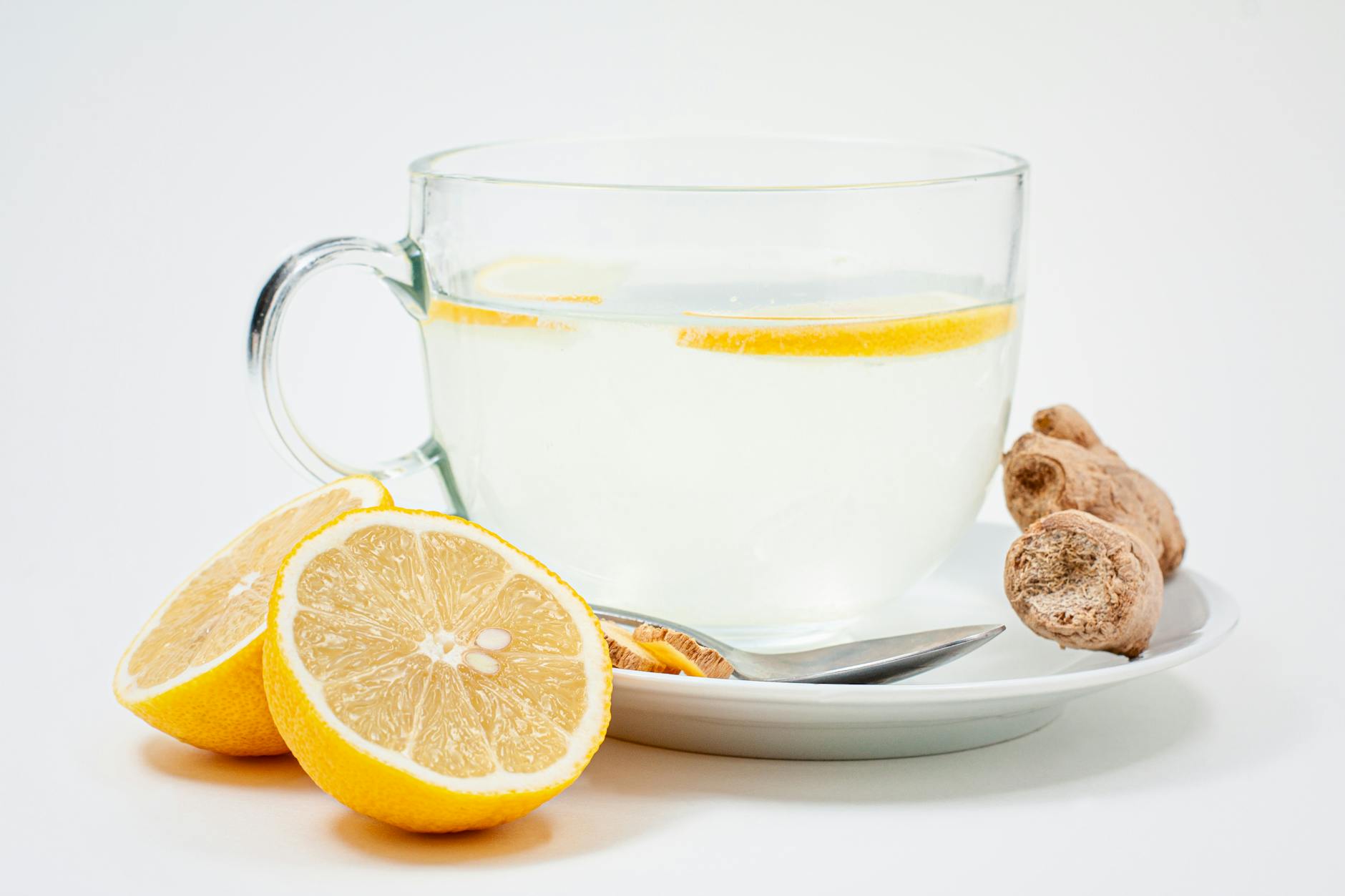 A soothing cup of lemon ginger tea with fresh lemon slices and ginger root on a white background. - boost immunity naturally