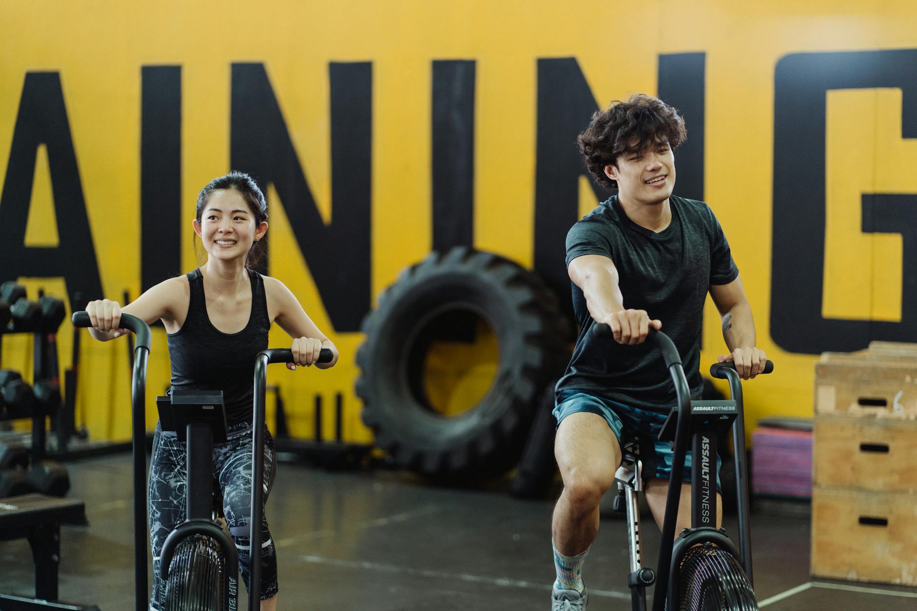Happy couple enjoying an indoor cycling workout together, enhancing fitness and having fun. - may cardio workouts