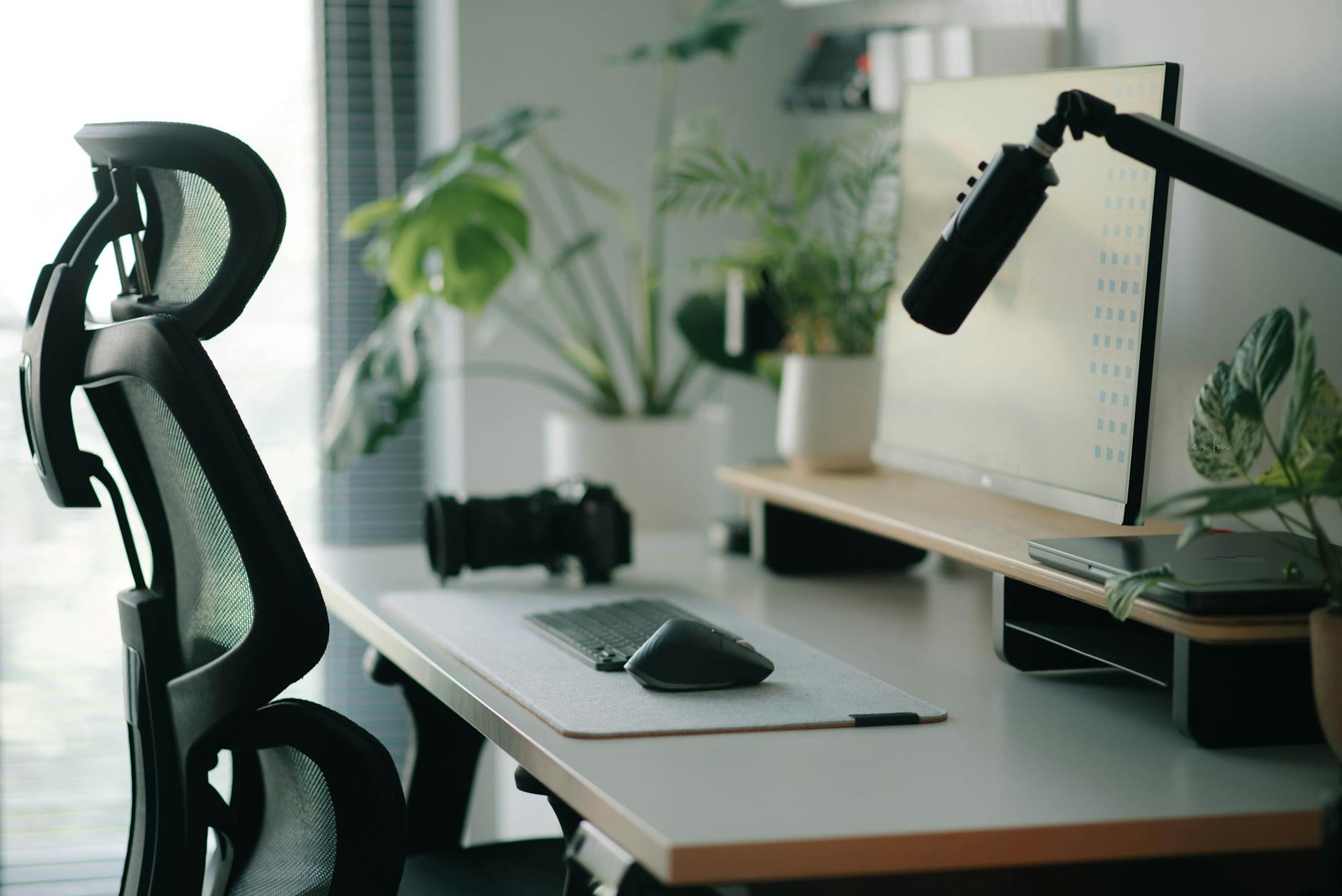 Stylish home office setup with ergonomic chair, plants, and tech accessories creating a modern work environment. - desk exercises