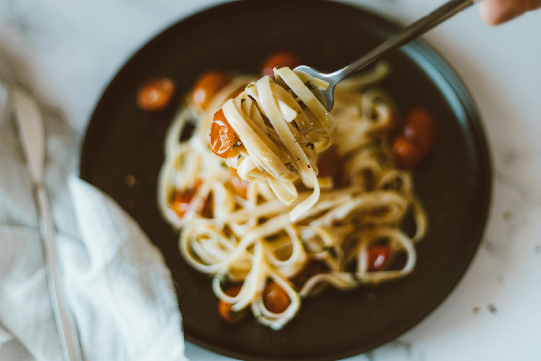 A close-up shot of Italian pasta garnished with cherry tomatoes, perfect for dinner. - easy weeknight dinners