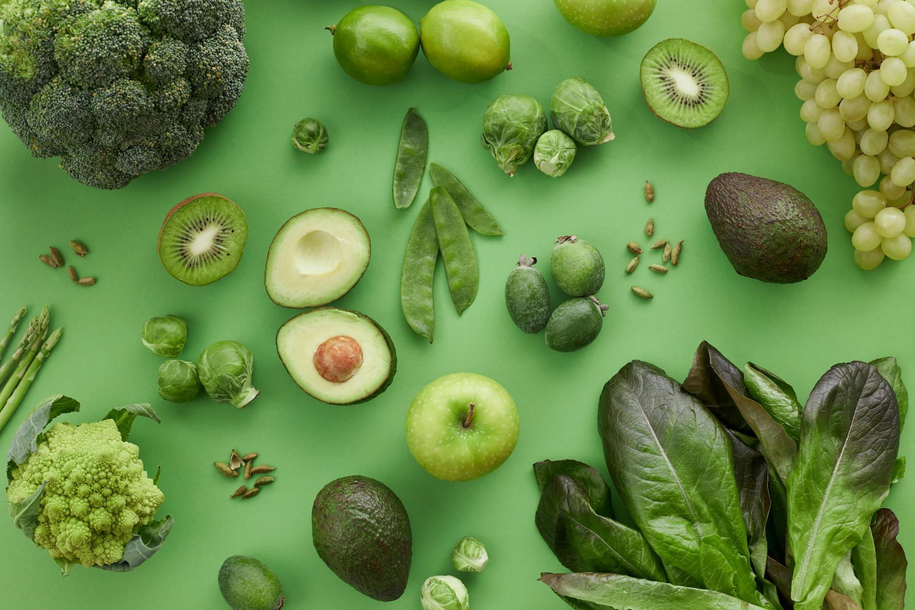Top view of assorted fresh green vegetables and fruits on a green background, perfect for healthy lifestyle visuals. - fiber foods fullness