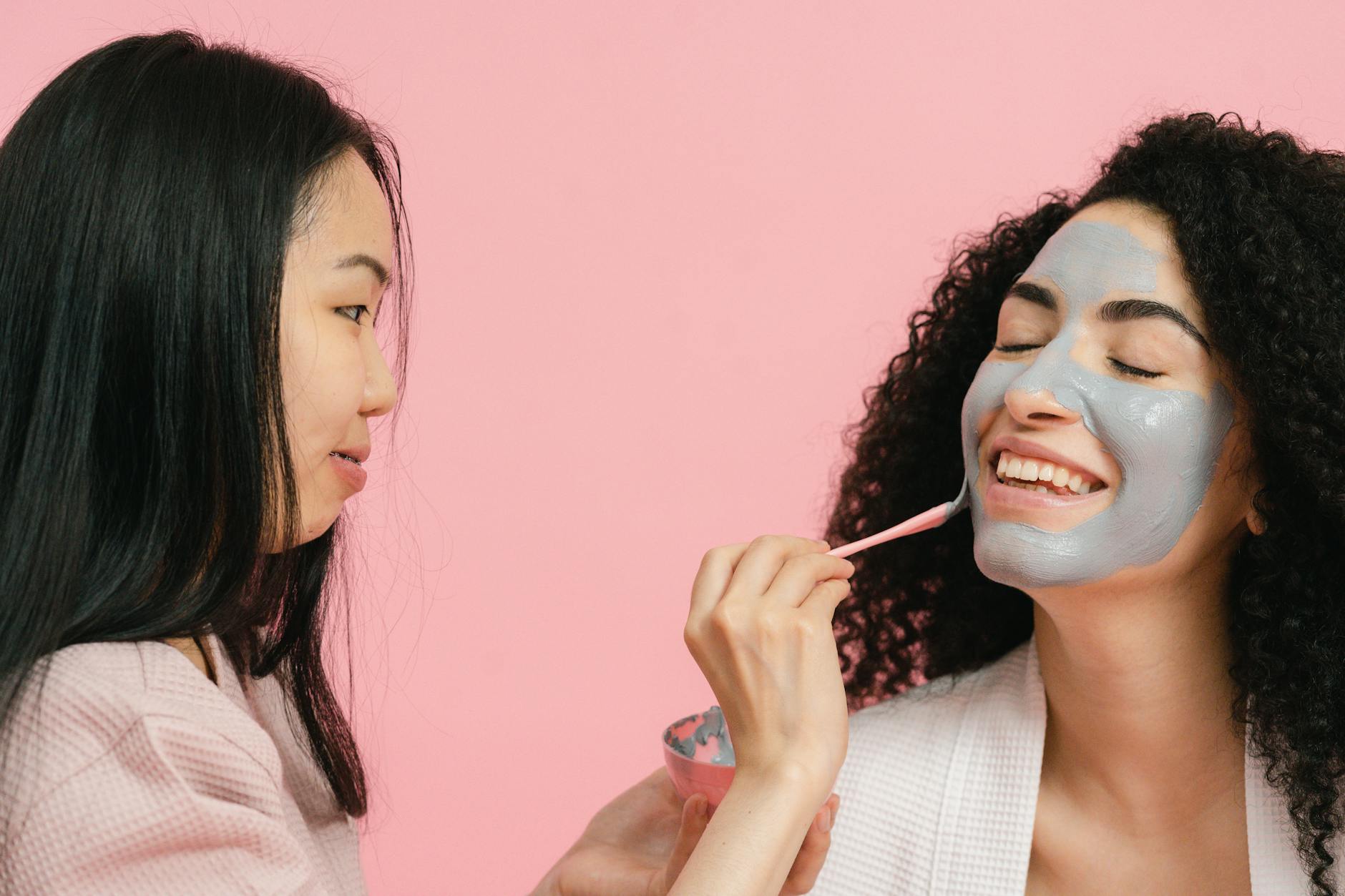 Two women enjoying a relaxing facial clay mask session in a studio setting. - glowing skin recipes