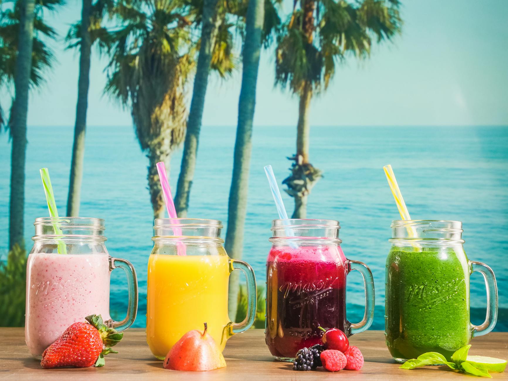 Vibrant smoothies in mason jars with a tropical ocean backdrop, perfect for refreshment. - green smoothie benefits