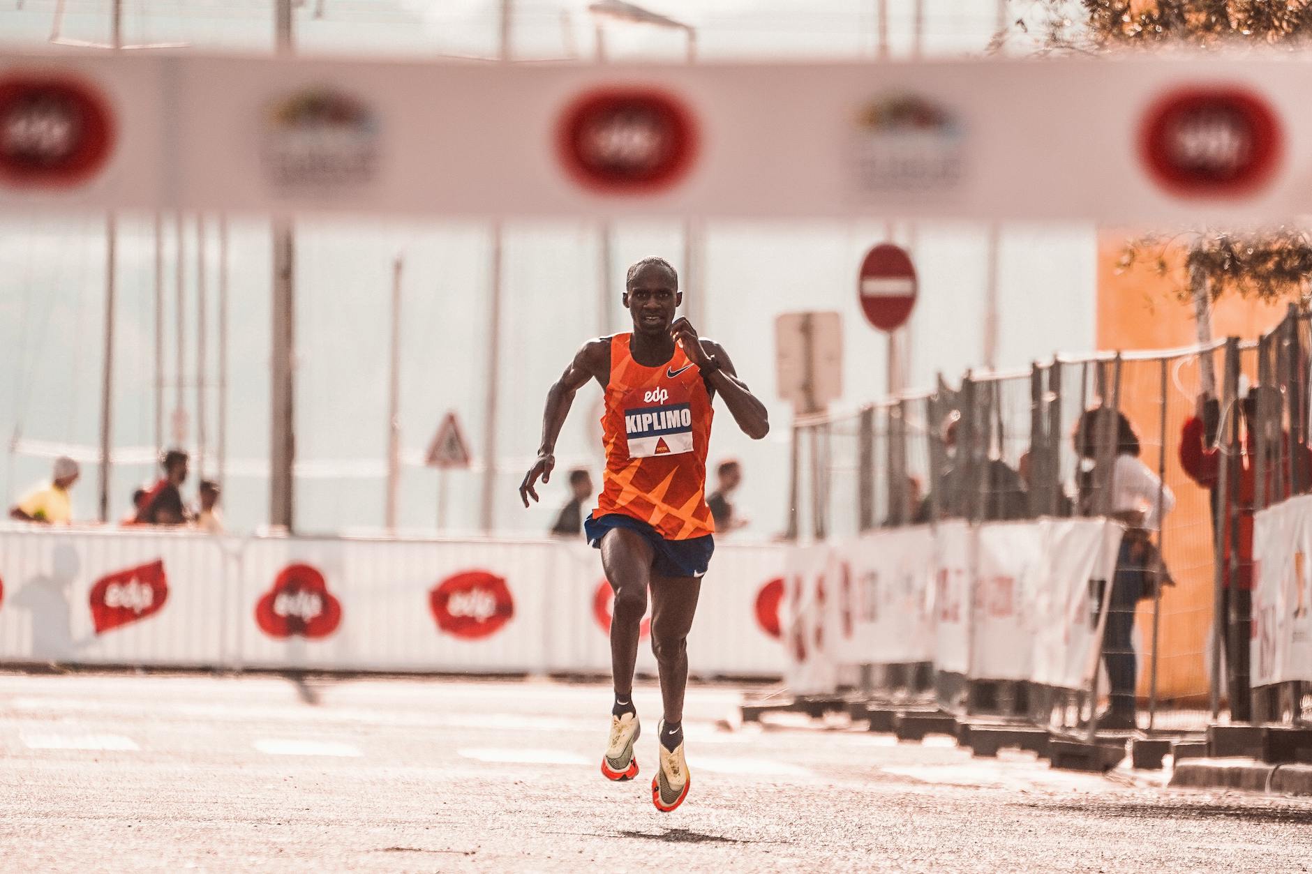 African male athlete competing in a marathon, showcasing endurance and speed in an outdoor urban race setting. - marathon recovery nutrition