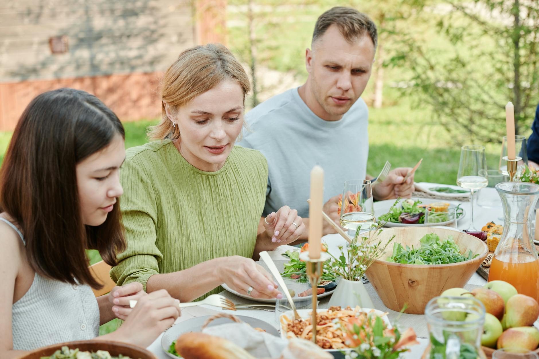 A family shares a meal outdoors, enjoying fresh and vibrant salads. - mindful eating may