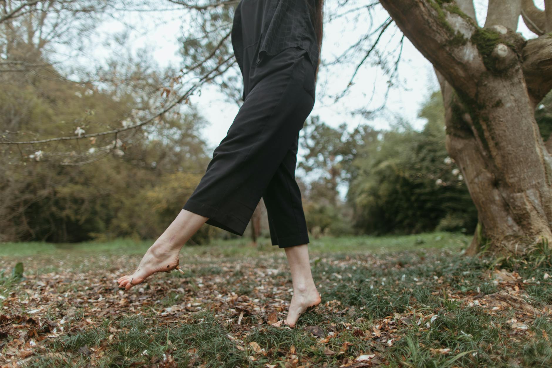 Person walking barefoot in nature, highlighting freedom and connection with the earth. - mindful walking nature