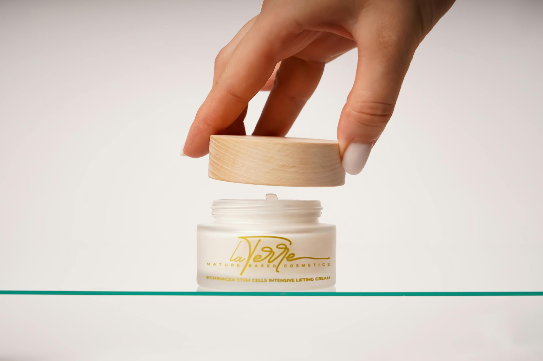Hand opening Echinacea stem cells lifting cream in minimalist setting. - nourish skin from within