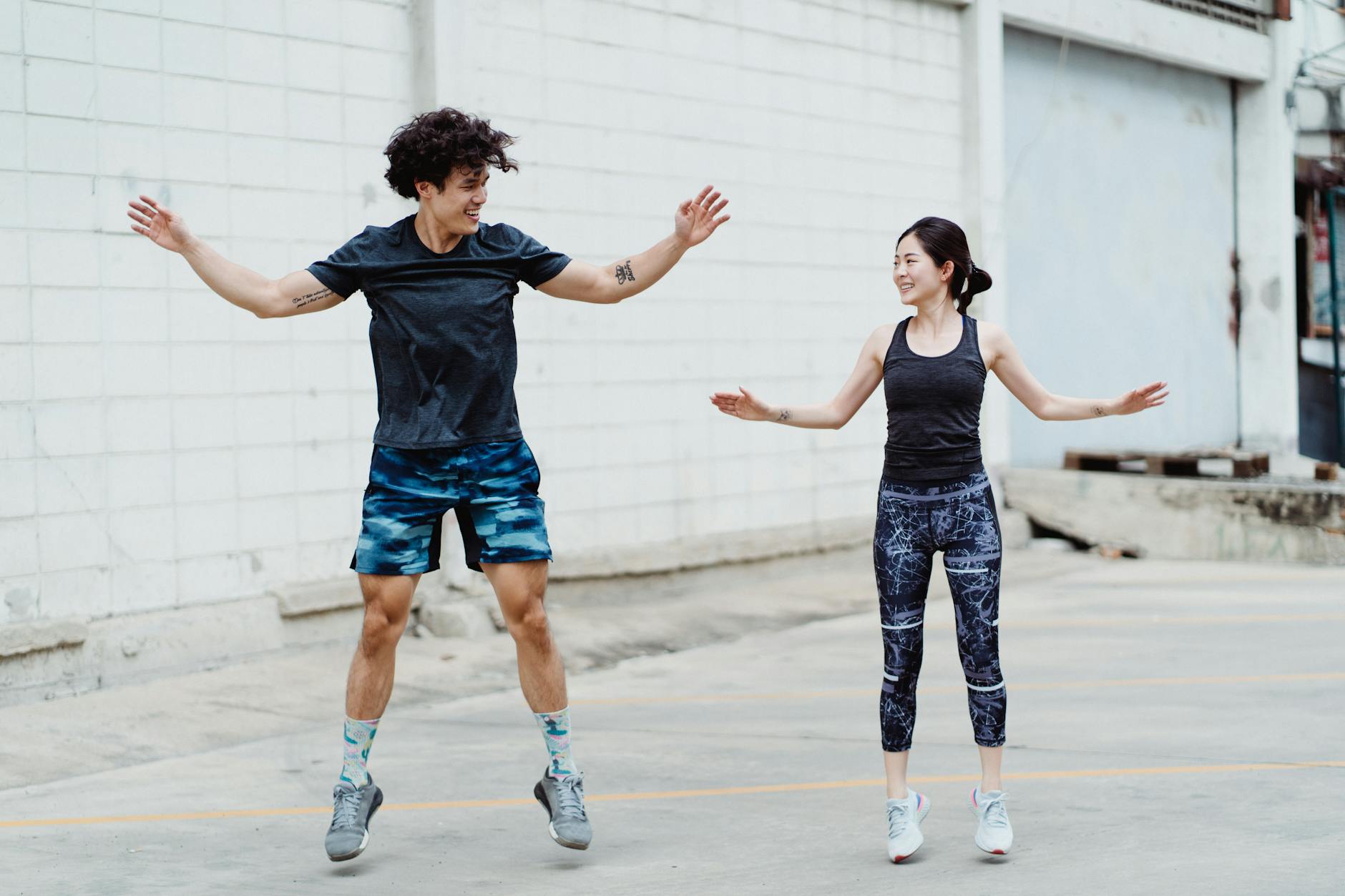 Two adults exercising outdoors, engaging in a fun fitness routine, showcasing energy and a healthy lifestyle. - outdoor cardio beginners