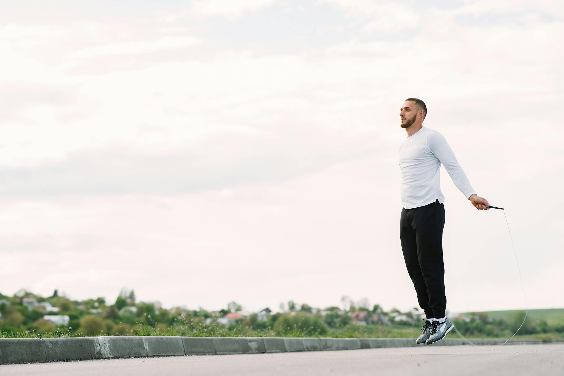 Man performing jump rope exercise outdoors for fitness and healthy lifestyle. - outdoor cardio workouts