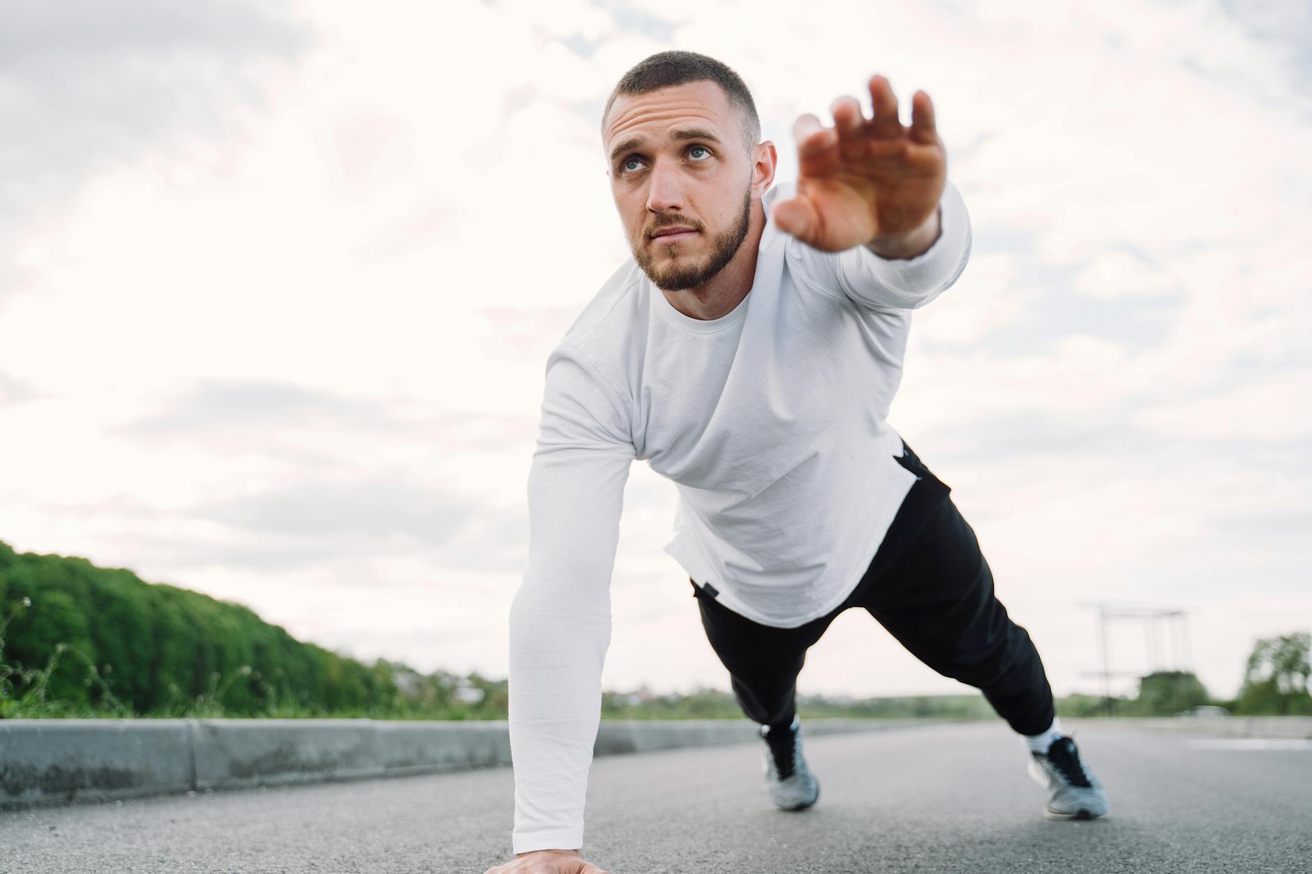 Adult male doing a core exercise on a rooftop in sportswear, promoting fitness and healthy living. - outdoor core workout