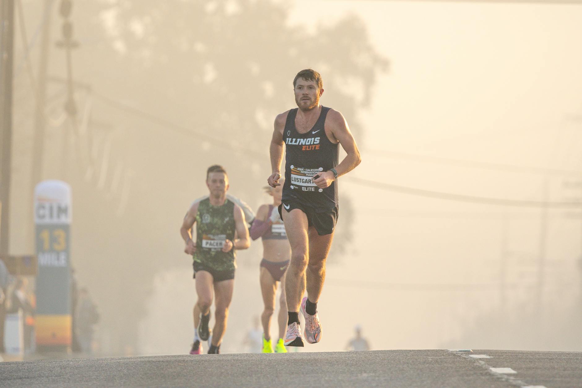 Athletes running a marathon at dawn, surrounded by fog and focused on the competition. - outdoor running pace