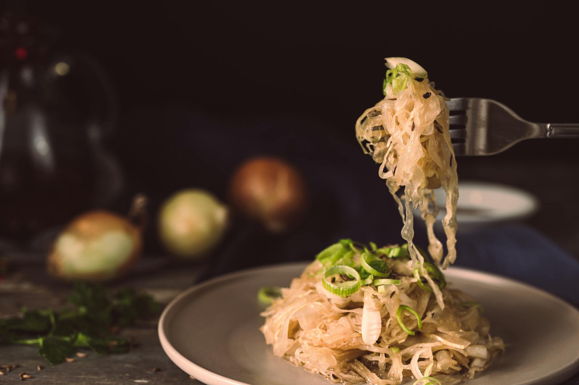 A mouthwatering plate of sauerkraut garnished with green onions, ready to eat. - probiotic recipes gut health