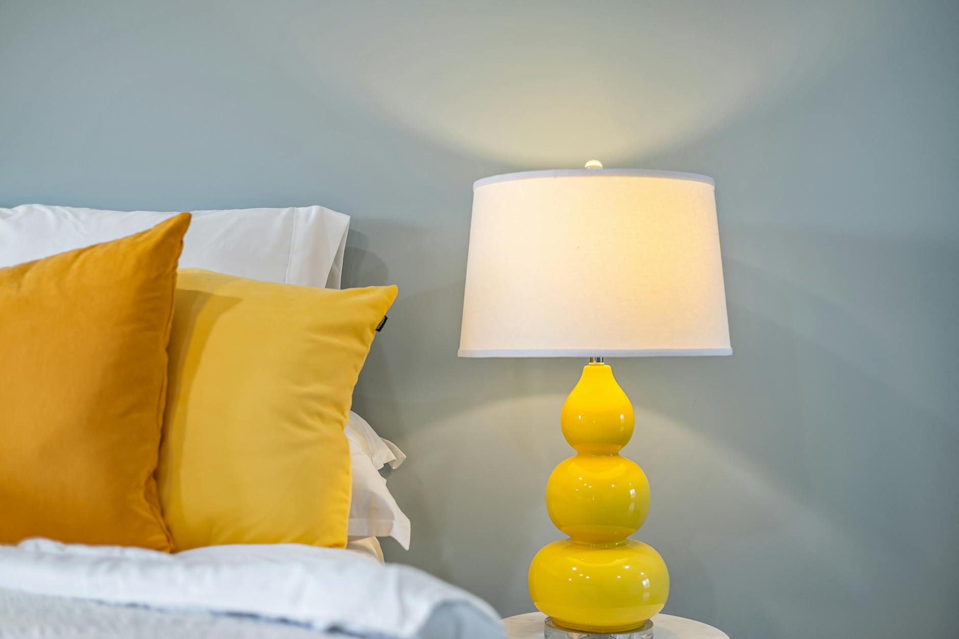 Cozy bedroom interior featuring yellow accents and a chic bedside lamp for a warm ambiance. - restful bedroom environment