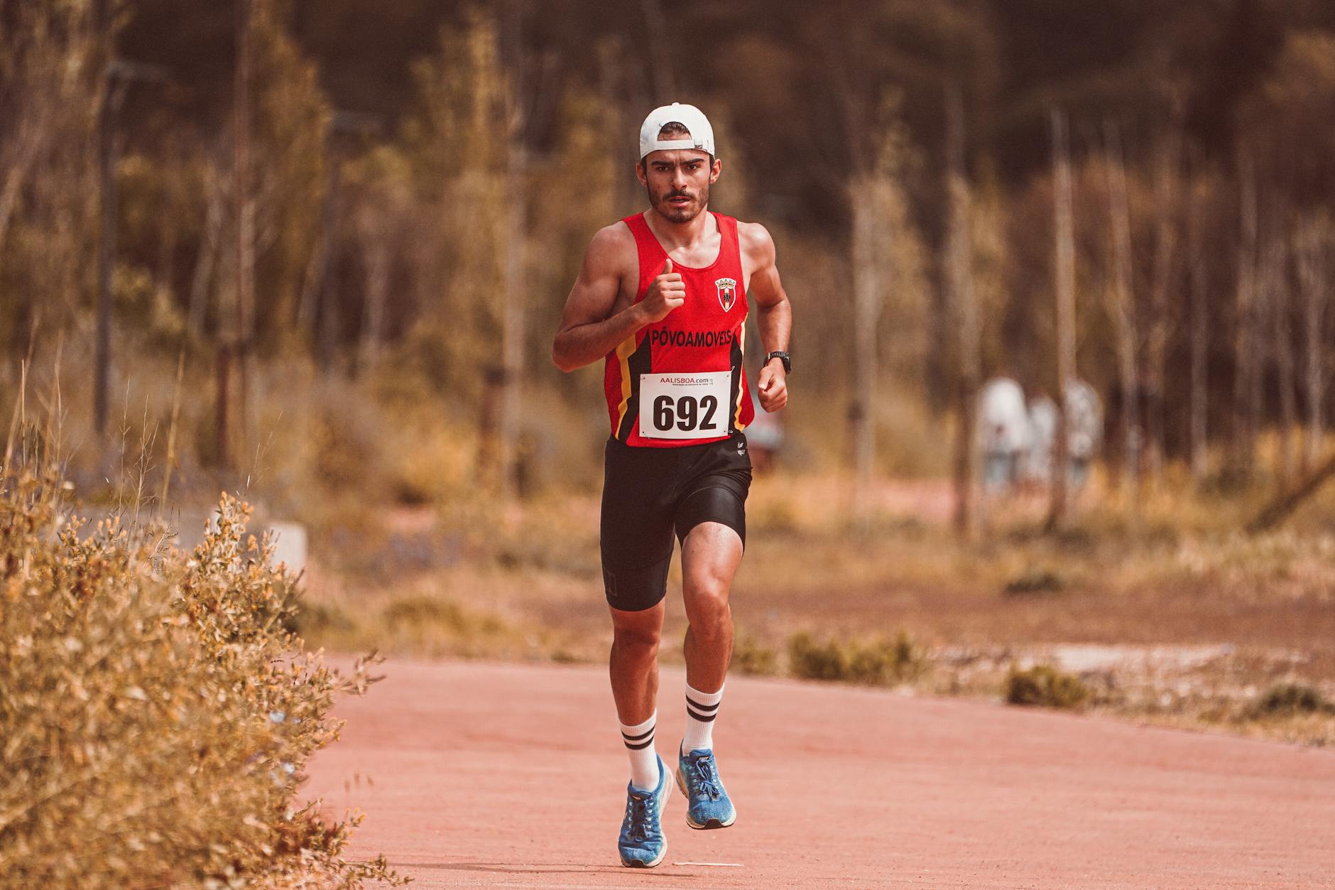 Athletic male runner participating in an outdoor marathon race on a sunny day. - running tips for beginners