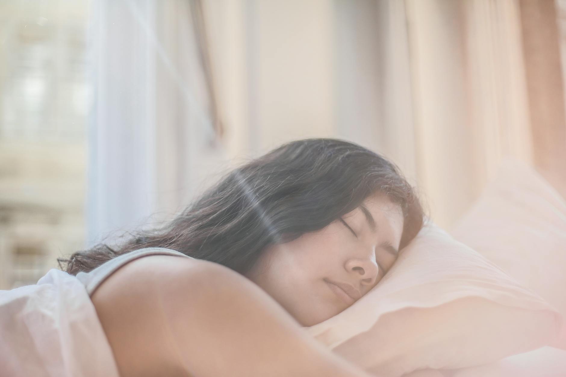Portrait of a woman sleeping peacefully in soft morning light indoors. - sleep cycle reset