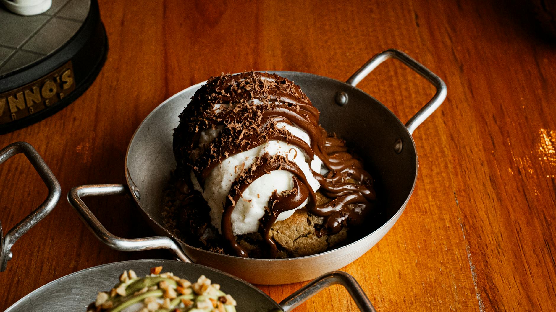 Indulge in a chocolate-topped ice cream dessert served in a rustic pan, perfect for sweet cravings. - spring cravings explained
