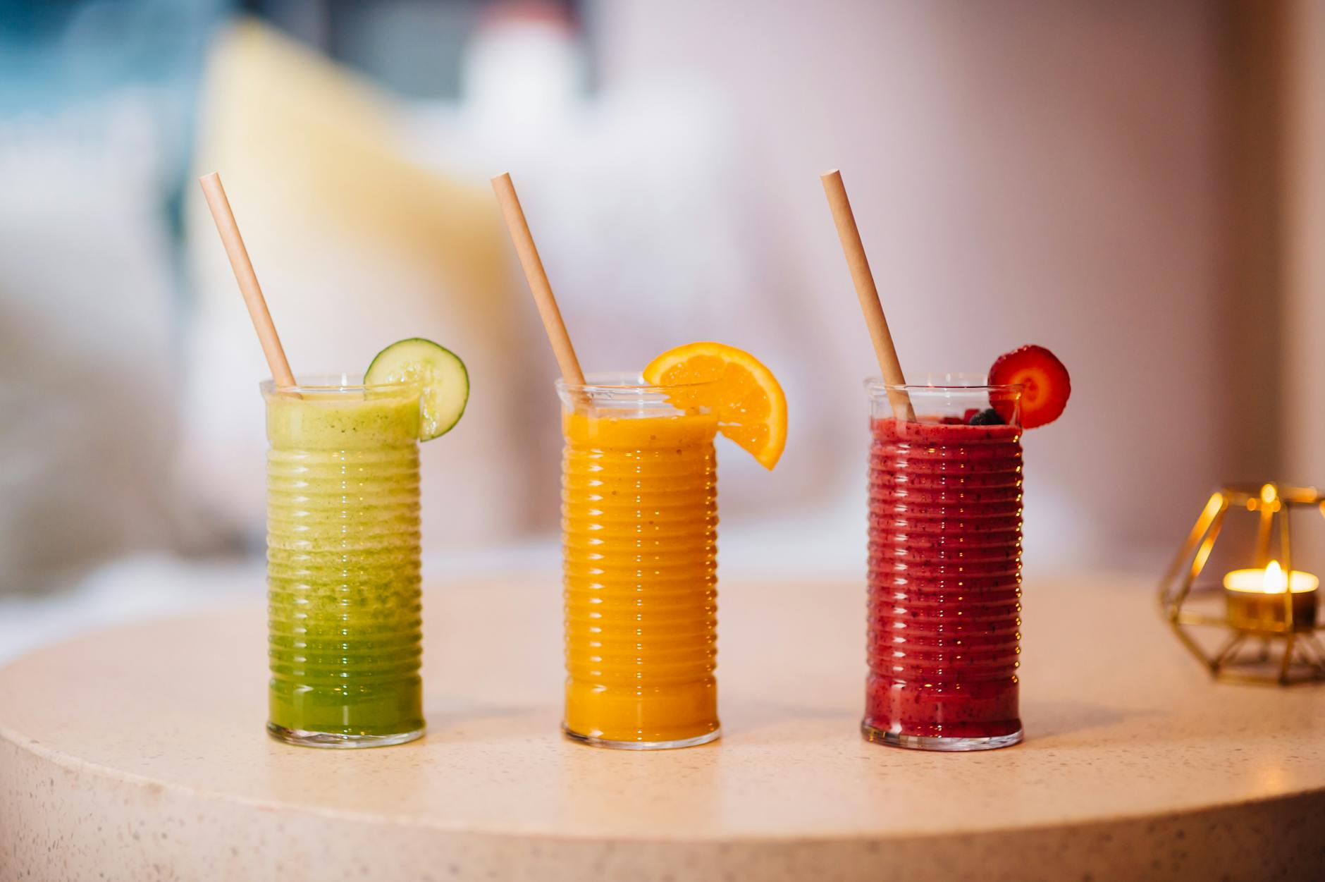 Three vibrant fruit smoothies with bamboo straws, perfect for a refreshing summer drink. - spring detox cleanse