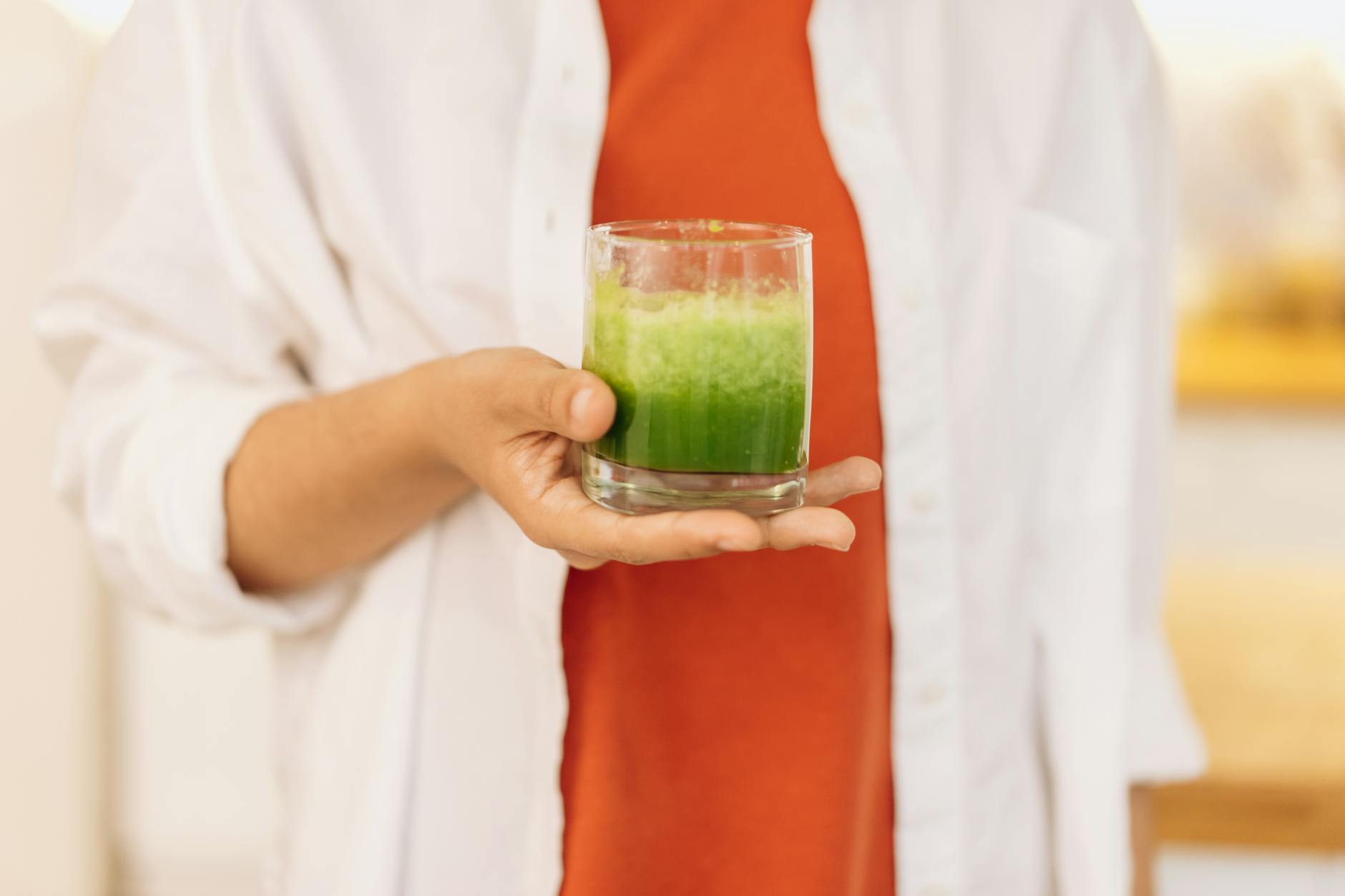 Close-up of a person holding a refreshing green smoothie, symbolizing a healthy lifestyle. - spring detox smoothie