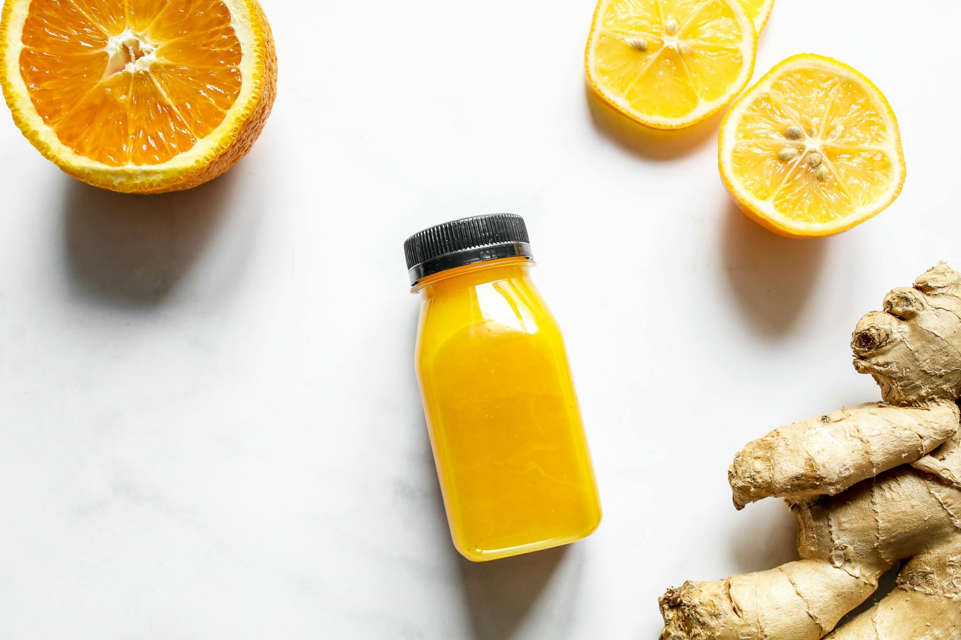 Bright and vibrant citrus juice with fresh ginger on a white background, perfect for health-focused content. - spring detox tips