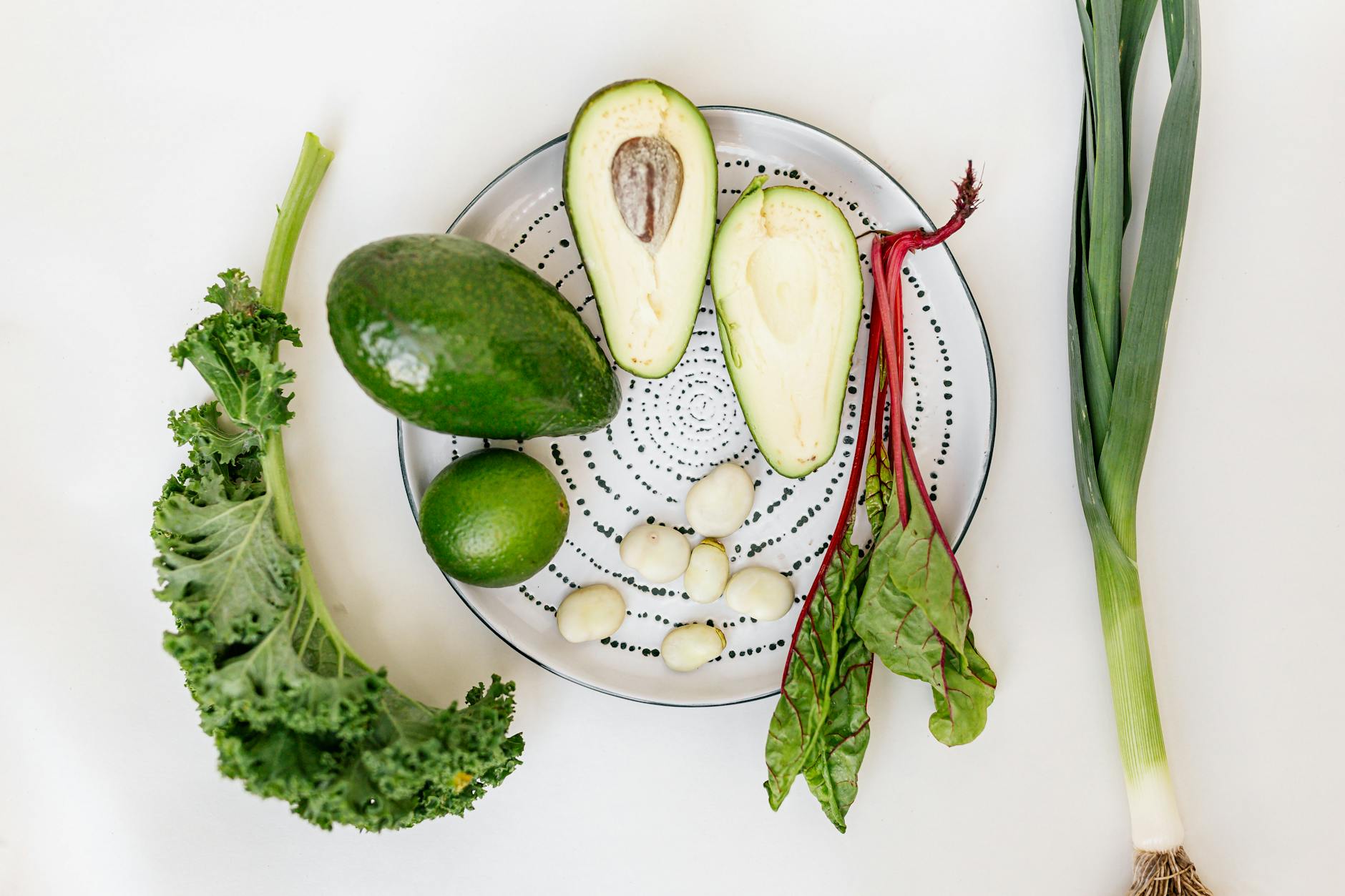 A vibrant flat lay of fresh vegetables and avocado on a plate. - spring detox tips