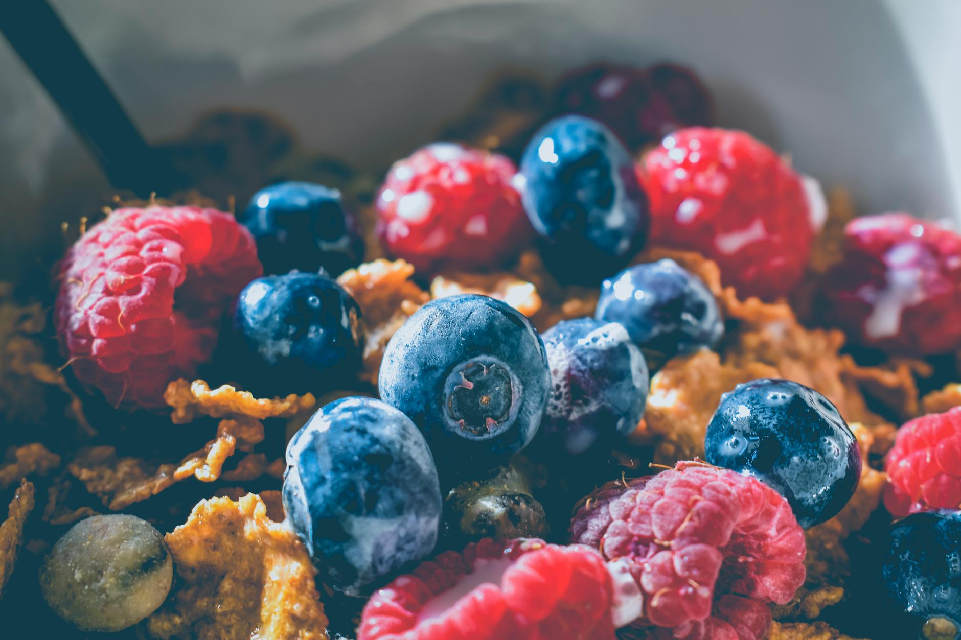 Close-up of a delicious and healthy breakfast with fresh blueberries and raspberries on cereals. - spring energy breakfast