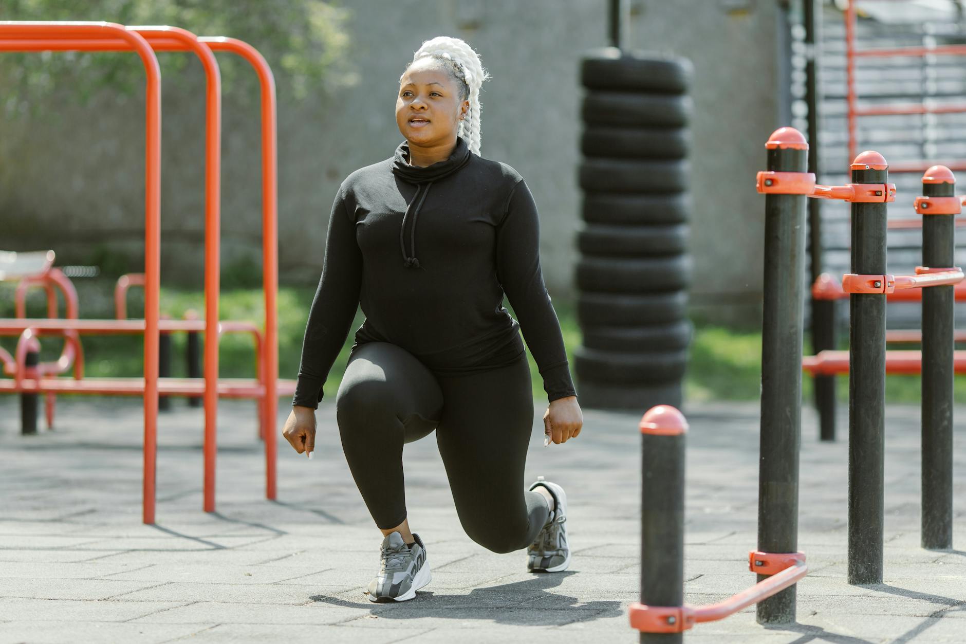 Fit woman performing lunges at an outdoor gym, embracing a healthy lifestyle. - spring exercise motivation