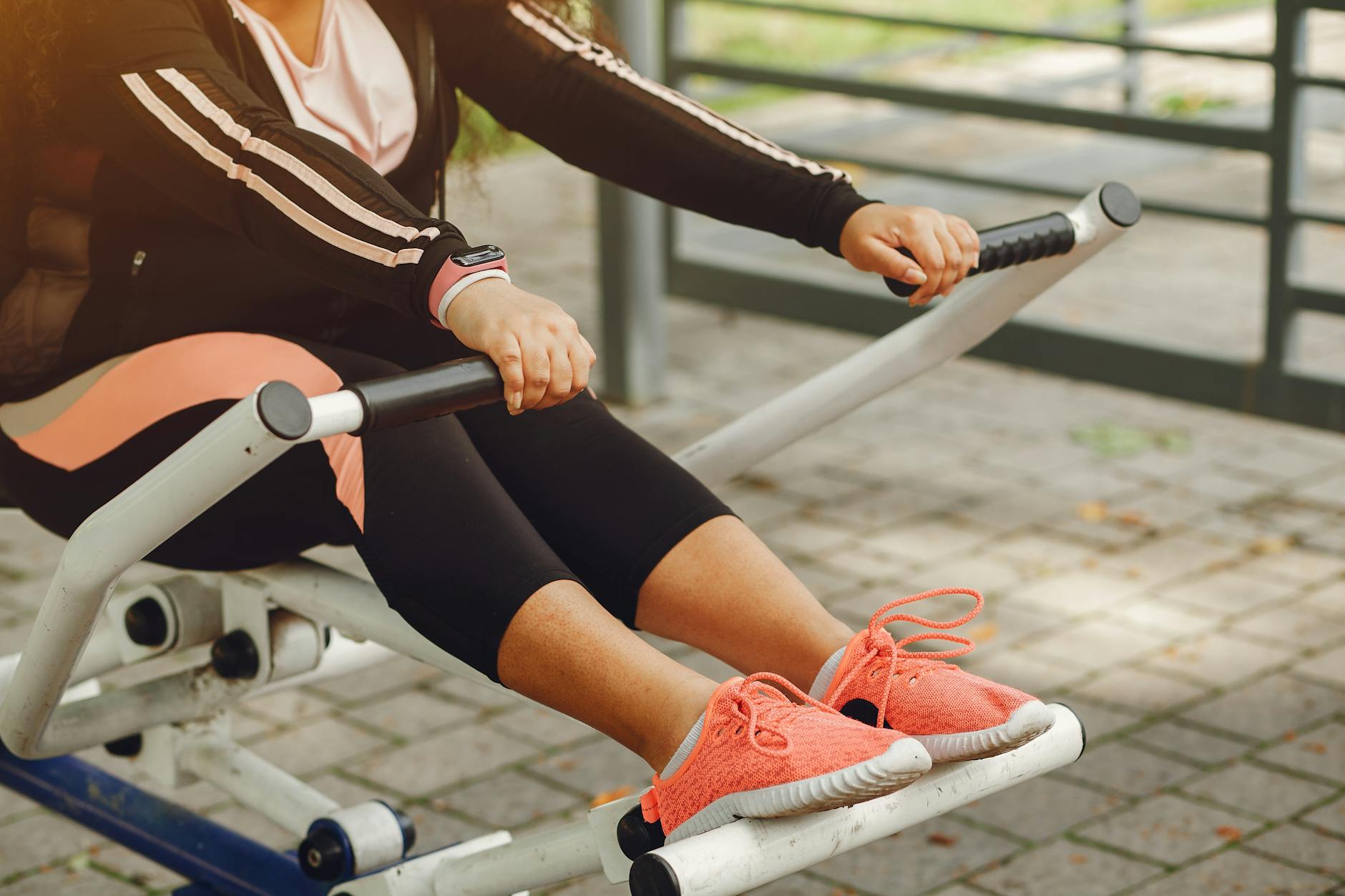 A woman in sportswear works out on outdoor fitness equipment, focusing on health and recreation. - spring exercise motivation