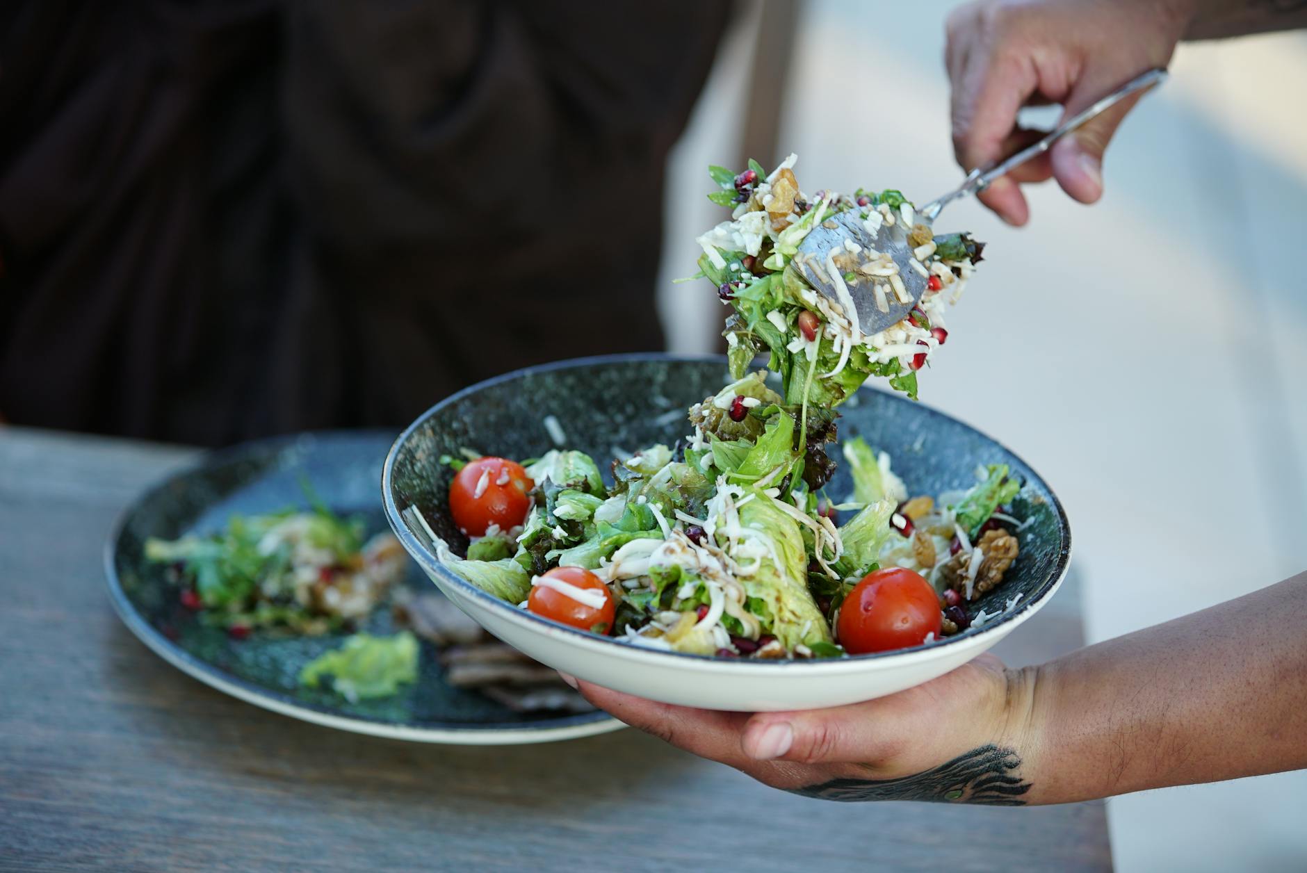 Colorful fresh garden salad with cherry tomatoes being served outdoors on a sunny day. - spring garden meals