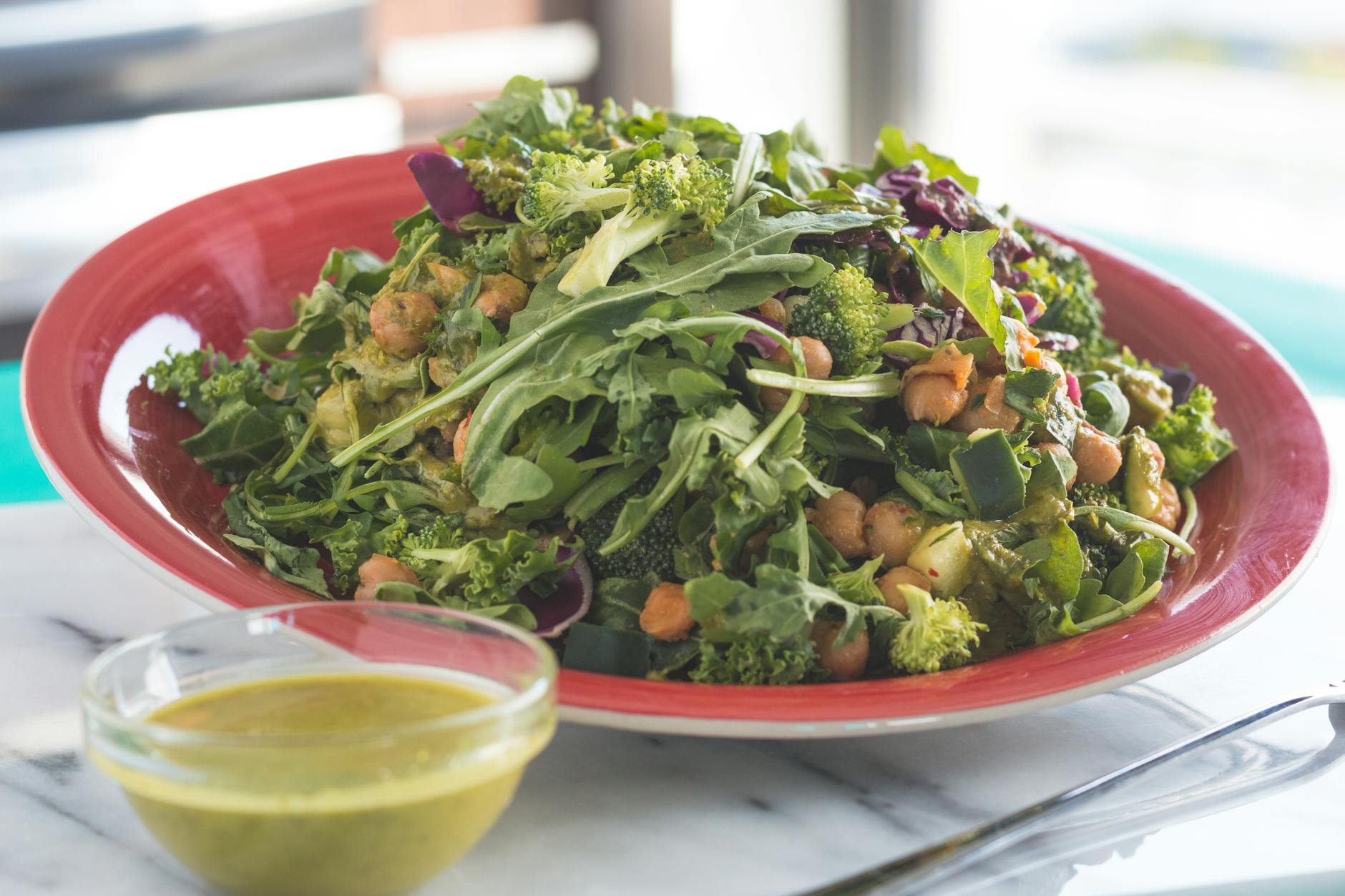 Healthy vegetable salad with chickpeas and green dressing on a table. - spring healthy recipes