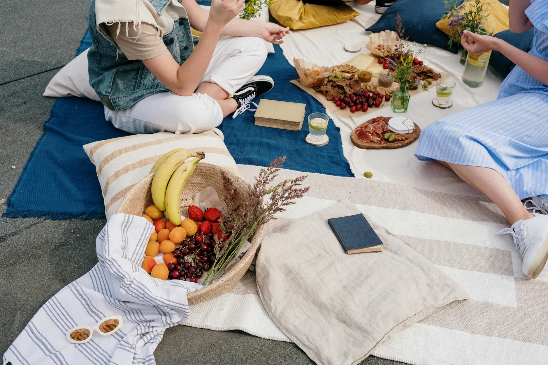 A vibrant outdoor picnic scene with fresh fruits, snacks, and friends enjoying a sunny day. - spring nutrition outdoor