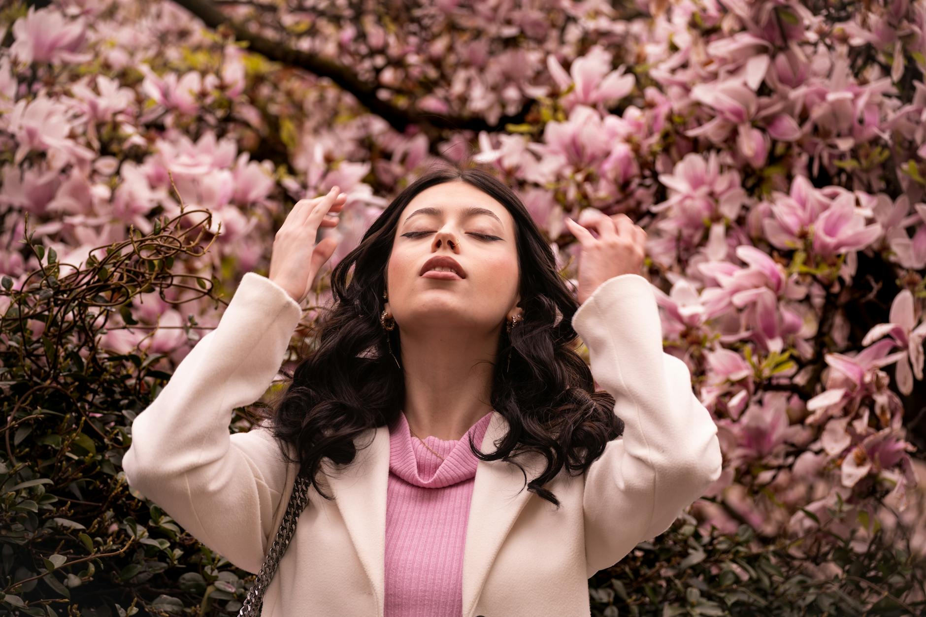 Elegant woman surrounded by vibrant spring blossoms in Milano, capturing seasonal beauty. - spring sad triggers