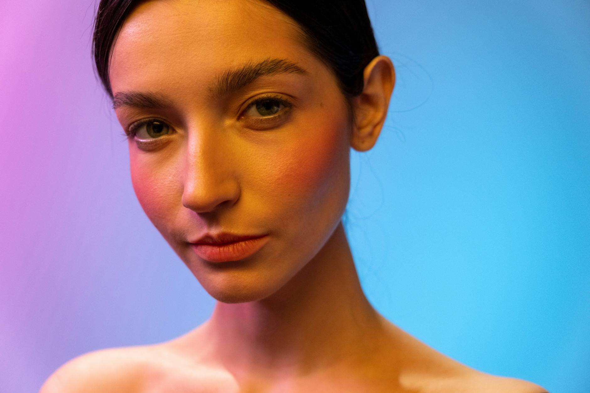 A woman in a studio with captivating neon lighting, showcasing beauty and elegance. - spring skin glow