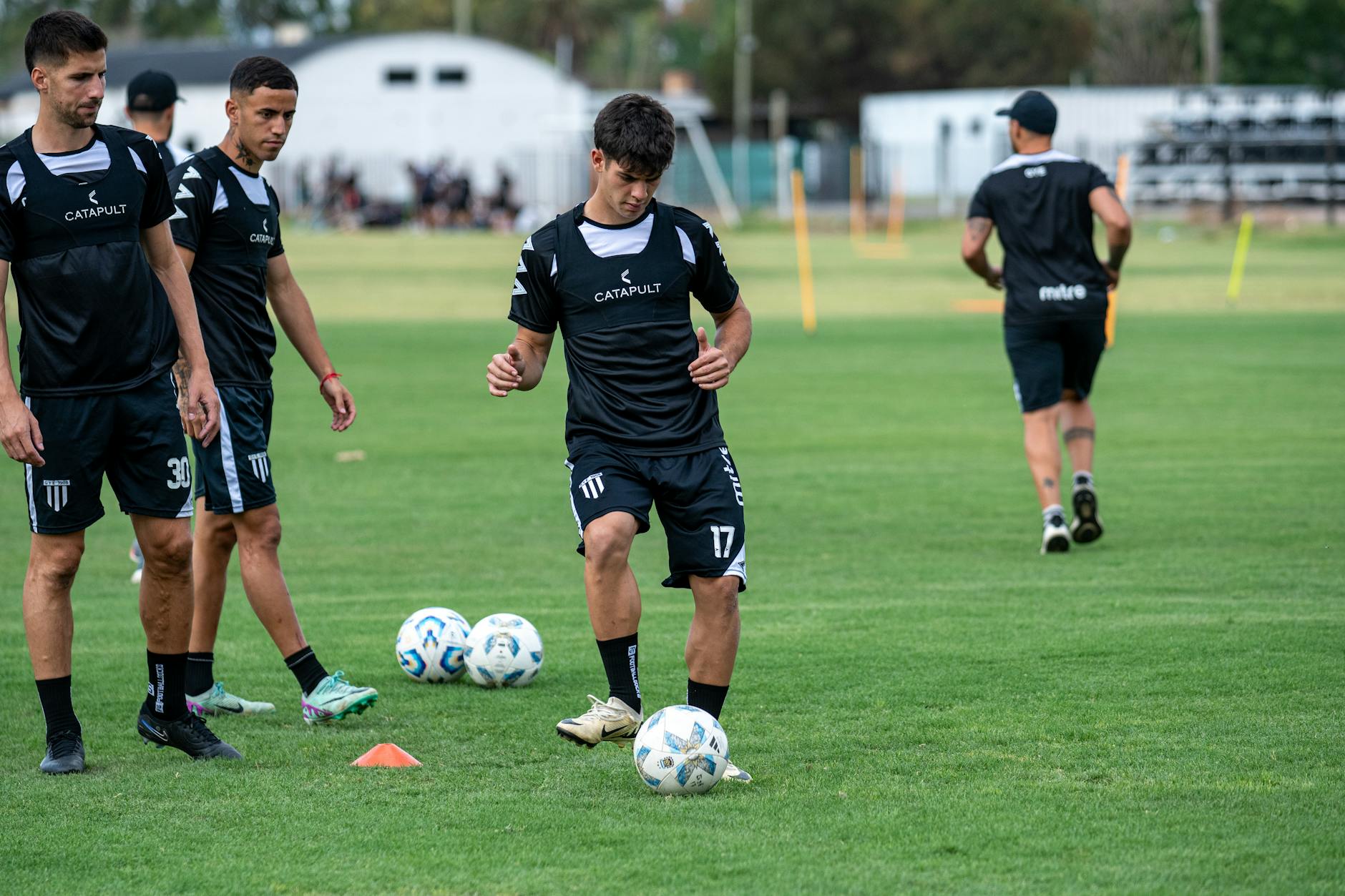 Young soccer players engaged in training on a grassy field with focus on foot skills. - spring training gear