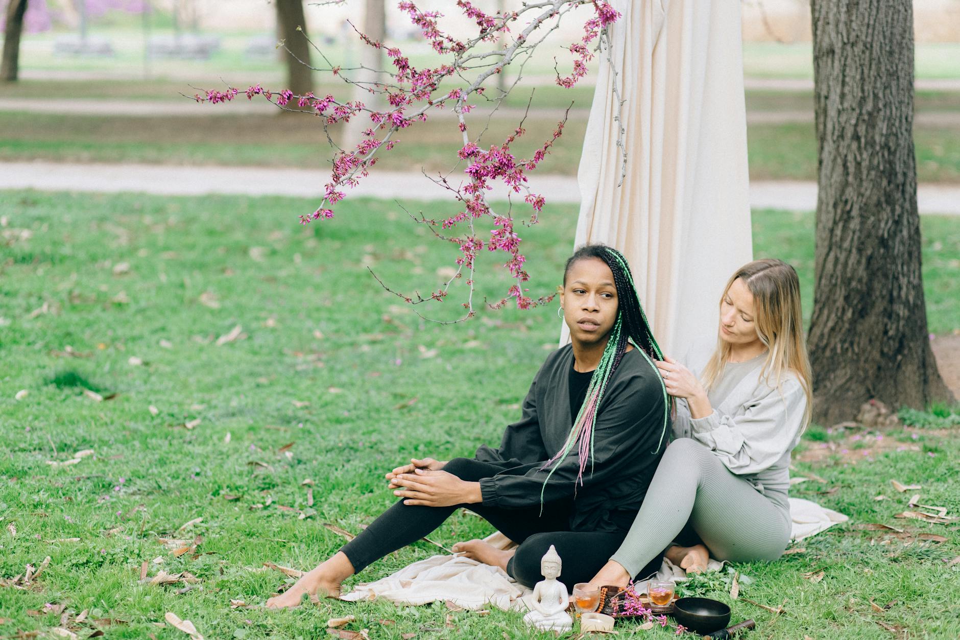 Two women enjoying an outdoor relaxation session with nature, focusing on wellness and tranquility. - spring wellness trends