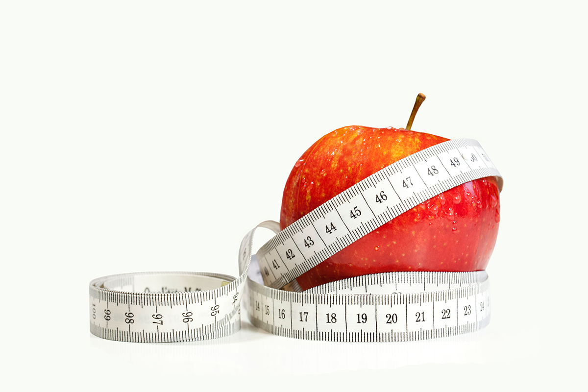 Weight loss concept with a measuring tape and an apple