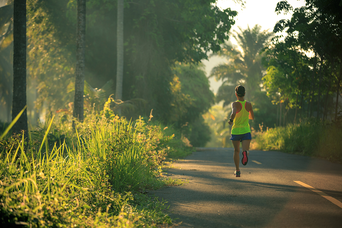 Individual experiencing mental benefits of exercise while running outdoors in nature
