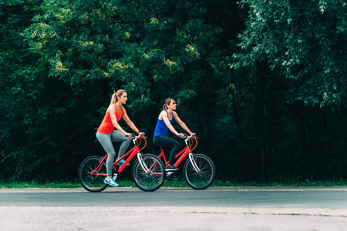 Two friends cycling together on a bike path