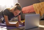 aking part in online fitness class in front of laptop.