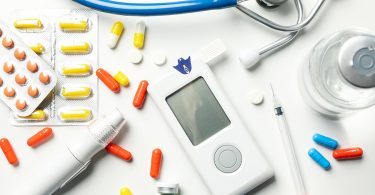 Top view of essential diabetes accessories laid out on a white background, symbolizing diabetes management tools