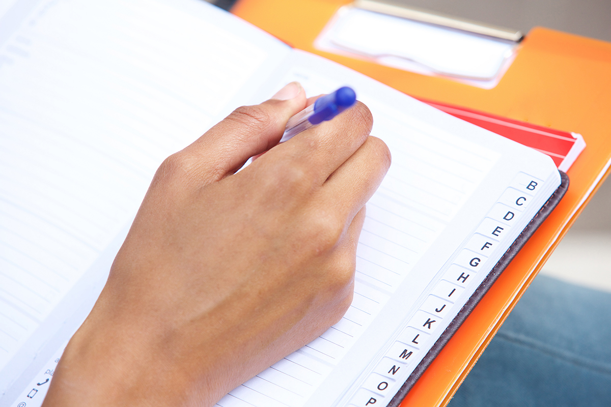 A woman jotting down important recommendations in a notebook, symbolizing the act of noting valuable tips and advice