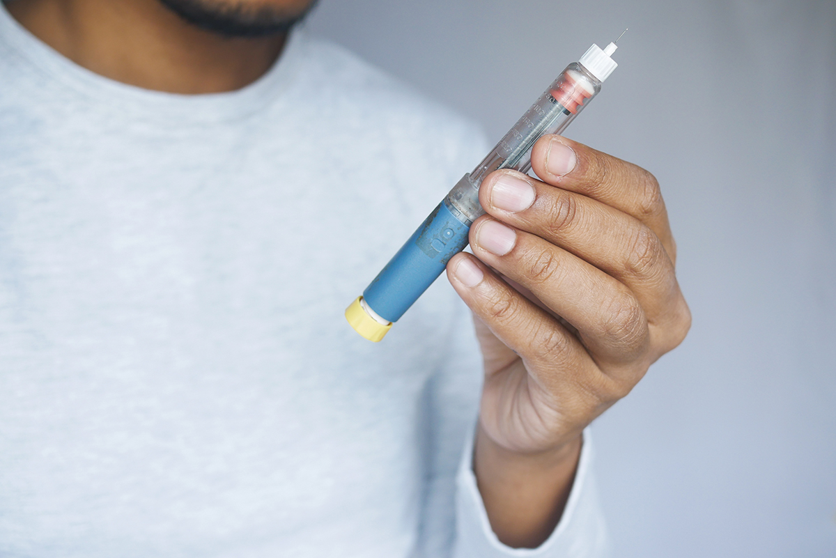 Close-up of a young man holding an insulin pen for diabetes management
