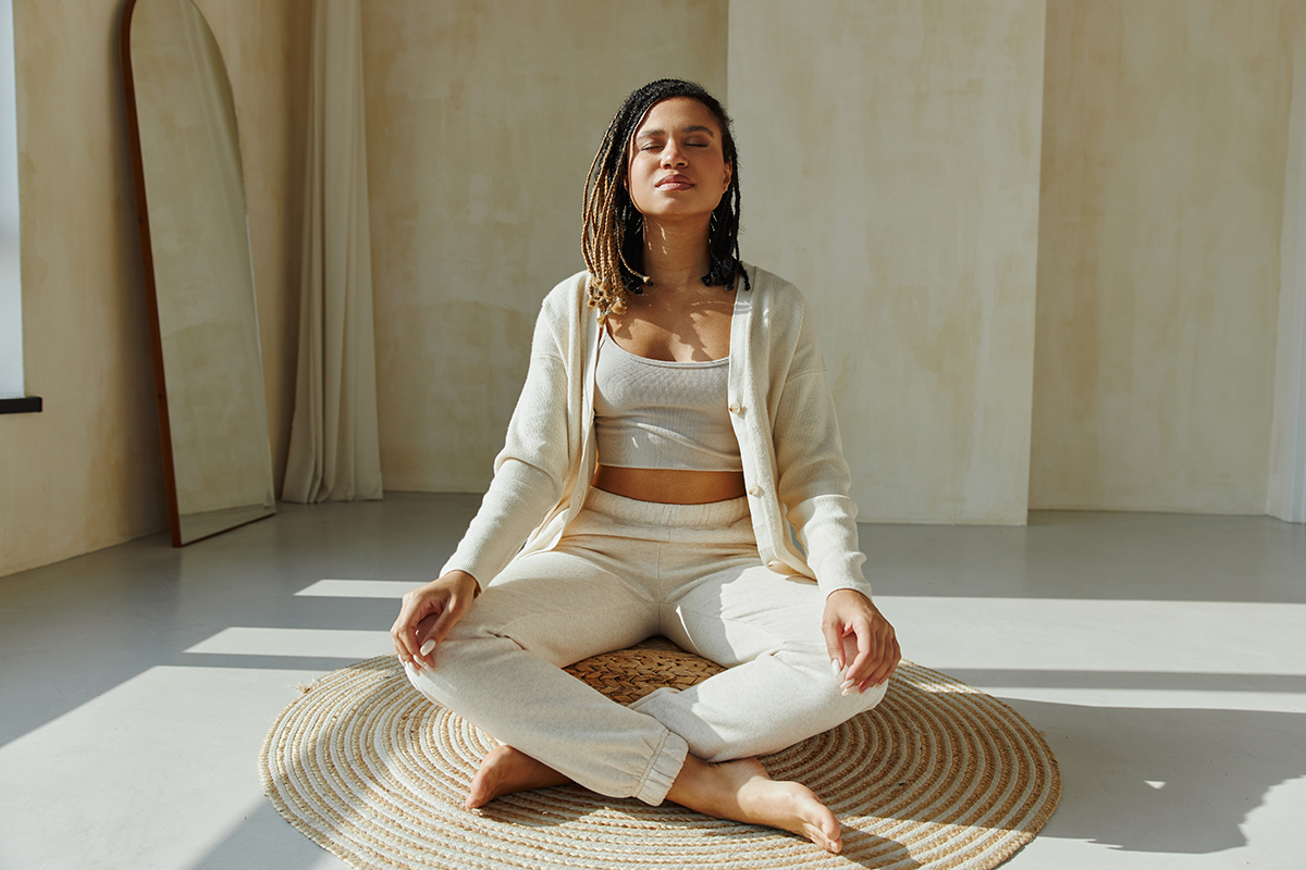 An individual in a peaceful meditation pose demonstrating what is heartfulness meditation amidst a serene setting